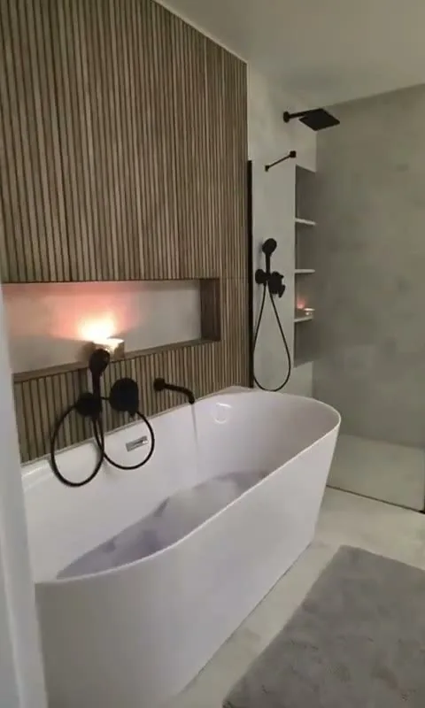 Badkamer in Vught met vrijstaand bad tegen een houten lamellenwand