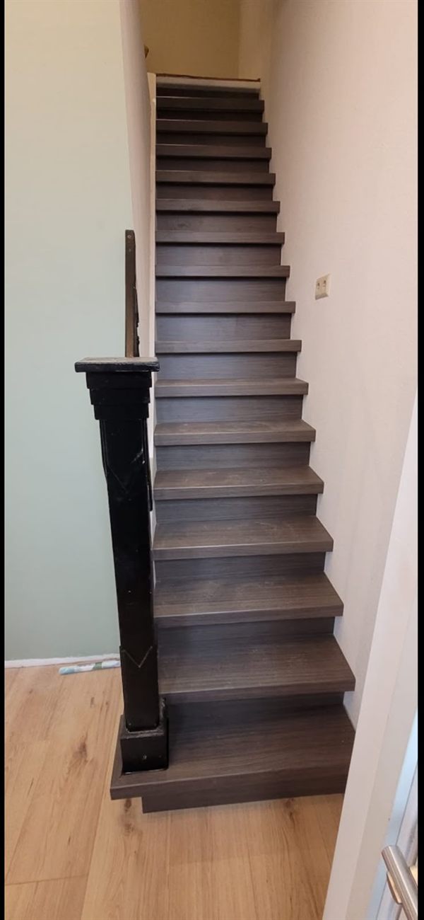 Gerenoveerde trap met nieuwe overzettreden in een houtlook uitvoering