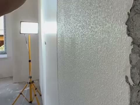 Stukadoor werkt een wand glad tijdens een complete renovatie